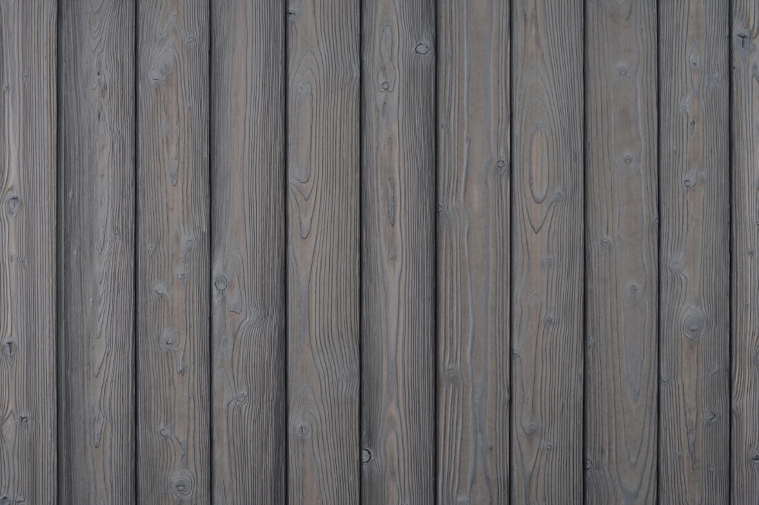 A detailed swatch of Degmeda's Light Grey Larch siding, showing its fine grain and consistent light grey charred finish.