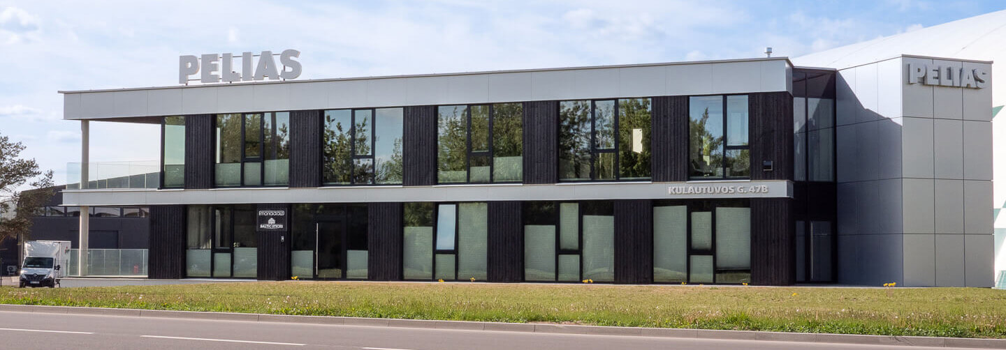 Close up of full street view of the Pelias office building in Kaunas, showcasing the rhythm of vertical Degmeda Deep Char Spruce cladding against modern glass and metal elements.