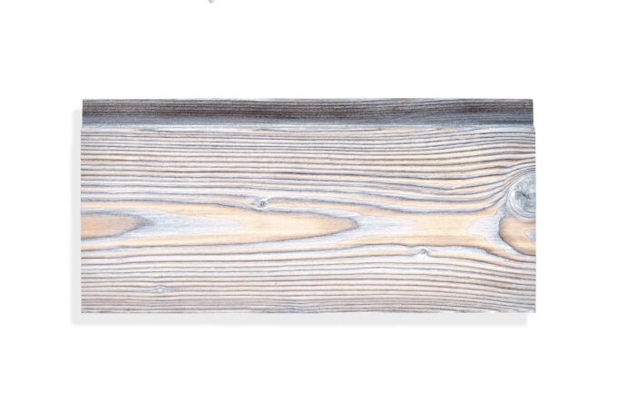 degmeda-single-peace-silver-grey-spruce-8.jpg Close-up of a weathered wooden plank showing pronounced grain and knots near the top edge.